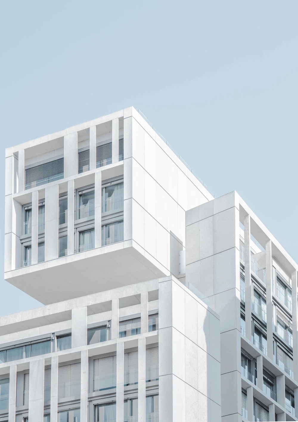 Mavi gökyüzü önünde beyaz modern yapı cephesi