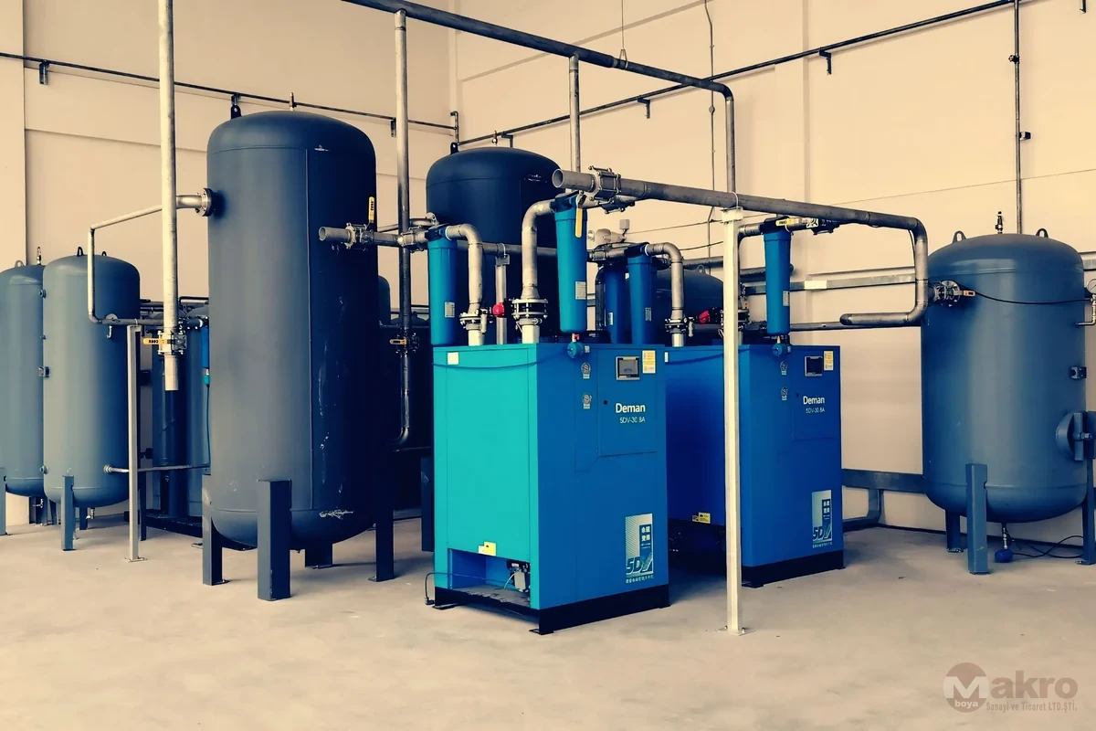 Endüstriyel bir tesiste mavi basınçlı hava tankları ve borular