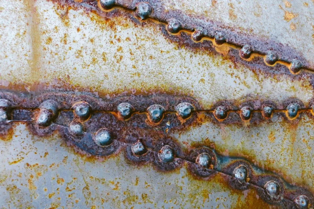 Metal levhada kaynak hatları çevresinde görülen paslı yüzey ayrıntısı