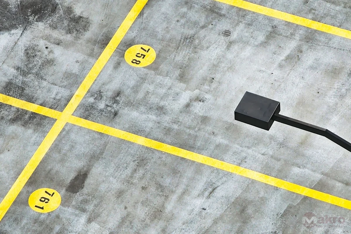 Üstten görünümde sarı park çizgileriyle bölünmüş boş otopark alanı
